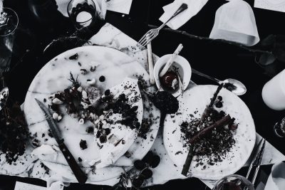 Leftover food on marble plates after hotel dining service, illustrating food waste in hospitality F&B operations