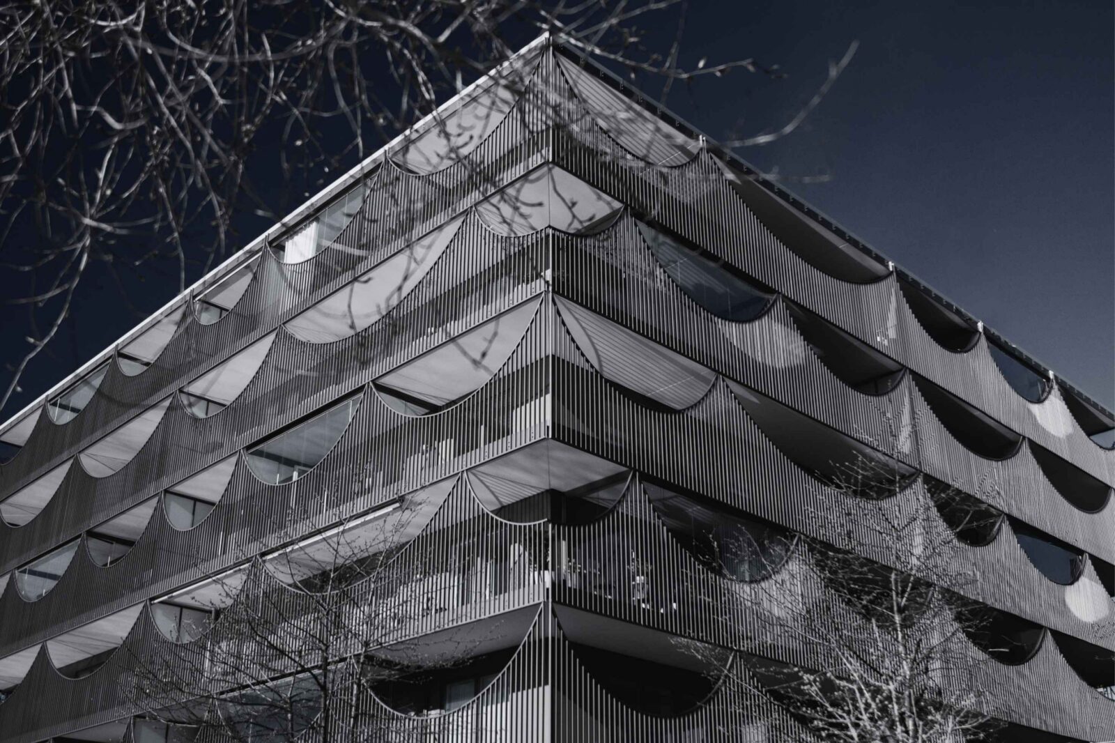 Modern hotel facade with mixed glass and wood panel cladding, illustrating how building design shapes a hotel's sustainability performance
